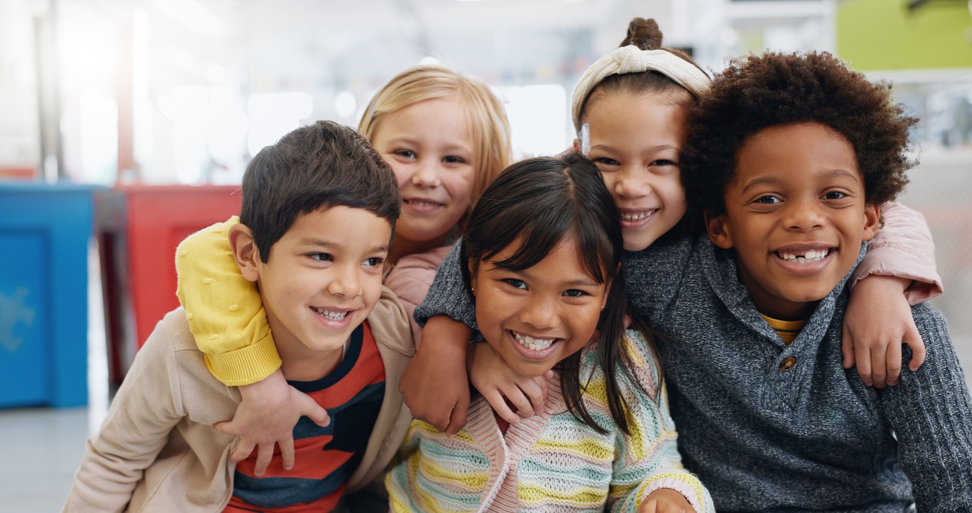 Porträt, Gruppe und Kinder mit Lächeln in der Schule für Bildung, Lernen und Wissen mit Umarmung. Student, Kinder oder Gesicht mit Glück im Klassenzimmer für Studium, Stipendium oder Kindheitsentwicklung